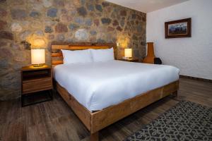 乔卢拉Hotel Boutique Camino Del Bosque by Rotamundos的一间卧室配有一张大床和两张台灯。