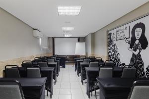 卡鲁阿鲁西蒂卡鲁阿鲁酒店的一间空的讲座室,配有黑色椅子和白色板