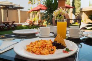 乔卢拉Capital O La Huerta Golf & Hotel的桌上的一盘食物,加上一杯橙汁