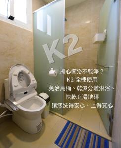 台东二高轻旅 K2 Hostel 的浴室设有卫生间,墙上有标志