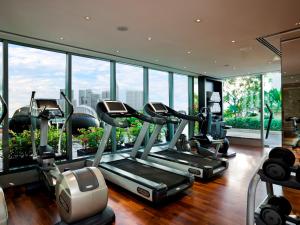 新加坡The Fullerton Bay Hotel Singapore的带有氧器材的健身房,位于带窗户的大楼内