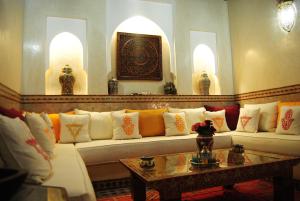 马拉喀什里亚德画廊49号庭院旅馆的客厅配有带色彩缤纷枕头的白色沙发