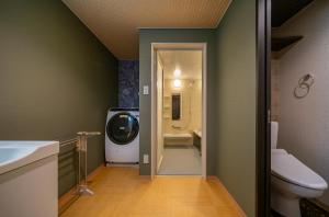 高山Residence Hotel Takayama Station的一间带卫生间的浴室和一台电视。