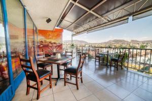 底拉斯卡拉Hotel De La Loma的一间带桌椅的餐厅以及一个阳台