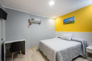 纳赫拉Apartamentos Turísticos San Lorenzo的一间卧室设有一张床和黄色的墙壁