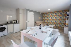 纳赫拉Apartamentos Turísticos San Lorenzo的白色的用餐室配有白色的桌椅