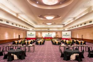雅加达Royal Palm Hotel & Conference Center Cengkareng的宴会厅,配有桌椅