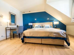于尔叙珀德优斯贝尔特城堡的一间卧室设有一张蓝色墙壁的大床