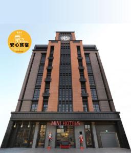 台中市MINI HOTELS(逢甲館)的一座高大的建筑,上面有钟