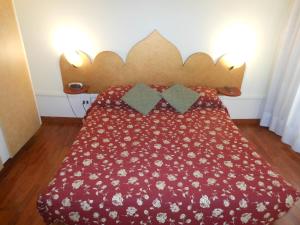 威尼斯卡德多赛酒店的一张床上的红色床罩,上面有鲜花