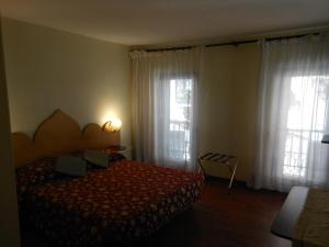 威尼斯卡德多赛酒店的一间卧室设有一张床和两个窗户。