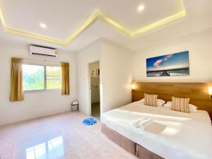 奈扬海滩Pensiri House - SHA Extra Plus的白色卧室设有一张大床和一个浴缸