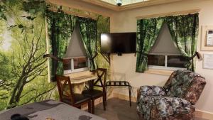 圣伊尼亚斯Bear Cove Inn的客房设有一张床、一张桌子和椅子。