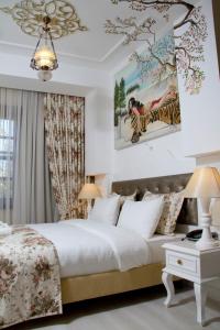 安塔利亚卡莱亦奇欧资卡夫客酒店的卧室配有一张床,墙上挂有绘画作品