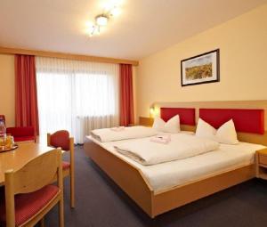 格拉芬维森Landhotel Buchbergerhof的酒店客房设有一张大床和一张桌子。
