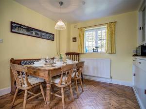 沃明斯特Foley's Cottage的一间带木桌和椅子的用餐室