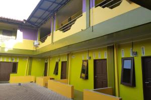 LubukpakamOYO 3487 Es Em Je Residence的一间黄色和绿色的墙壁和门的房间