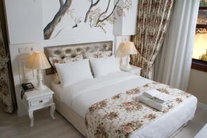 安塔利亚卡莱亦奇欧资卡夫客酒店的一间卧室配有一张白色大床,床上有鲜花