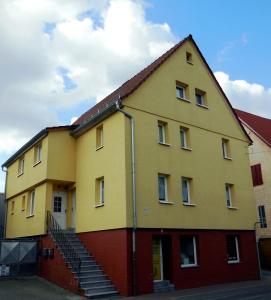 ReichelsheimFerienzimmer Gersprenztal的黄色的建筑,旁边设有楼梯