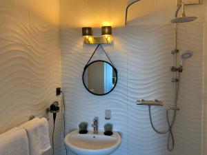 杜塞尔多夫Boutique Hotel Villa Sarah的一间带水槽和镜子的浴室