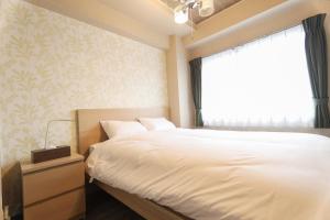 船桥市Chiba Nishi-funabashi Residence #MU1的卧室配有白色的床和窗户。