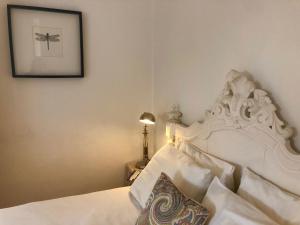 里斯本Charming Apartment in Alfama with river view!的卧室配有一张白色床,墙上挂着一幅画