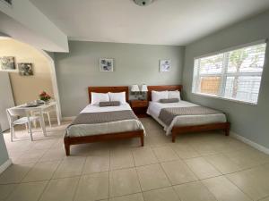 劳德代尔堡珊瑚钥匙酒店的一间卧室设有两张床、一张桌子和一个窗口