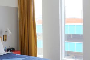 达拉姆达勒姆酒店的一间卧室设有一张床和一个滑动玻璃门