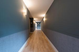 巴雷罗斯Rías Altas - Hotel Restaurante的走廊设有蓝色的墙壁和木地板