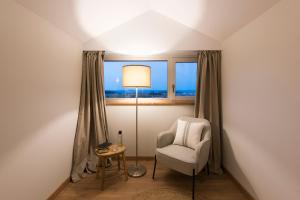 巴雷罗斯Rías Altas - Hotel Restaurante的一间带椅子、一盏灯和一扇窗户的房间