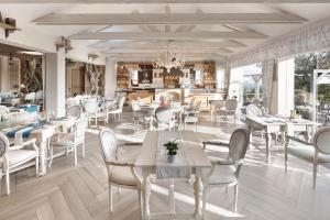 尼特拉Hotel Zlaty Klucik - Golden Key with Luxury SPA的一间设有白色桌椅的用餐室