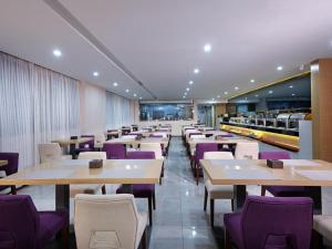 成都麗枫酒店·成都春熙路店的一间带桌子和紫色椅子的用餐室