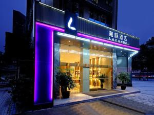 成都麗枫酒店·成都春熙路店的大楼前方有紫色灯的商店