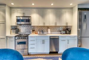 普罗温斯敦Provincetown Waterfront Studio的厨房配有白色橱柜和蓝色椅子