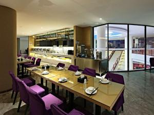桂林麗枫酒店·桂林市中心广场象鼻山景区店的餐厅设有一张长桌和紫色椅子