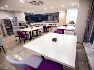重庆麗枫酒店·重庆西站巴国城店的餐厅配有白色桌子和紫色椅子