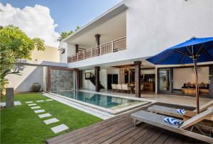 塞米亚克Danoya Private Luxury Residences的一座带游泳池和遮阳伞的房子的图片