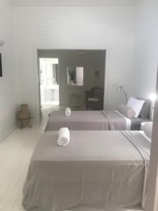 拜伦湾拜伦泉酒店的白色的客房配有两张床和一张沙发