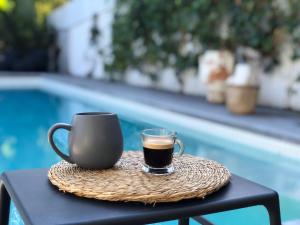 拜伦湾拜伦泉酒店的坐在游泳池畔的桌子上喝杯咖啡
