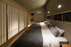 高松Kamome Jyuku的带大窗户的客房内的两张床