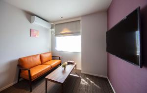 仓敷GRAND BASE Kurashiki Chuo的客厅配有橙色沙发和桌子