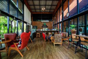 Ban Khlong Takhianวันสุขรีสอร์ทสุโขทัย的一间带桌椅的餐厅和一间酒吧