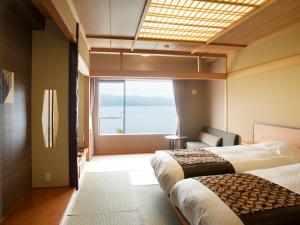 阿寒湖畔阿寒湖鹤雅之翼的酒店客房设有两张床和大窗户。