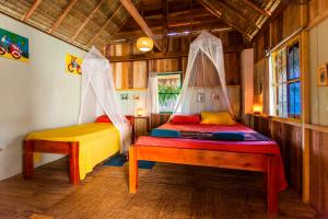 贡布Retro Kampot Guesthouse的一间卧室配有两张床,配有蚊帐。