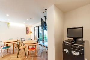 东京plat hostel keikyu haneda home的一间带桌椅和电视的用餐室