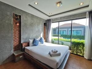 查龙BaanMee Phuket SHA Plus的一间卧室设有一张大床和一个大窗户