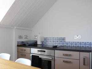 桑盖特The Eaves的厨房的墙壁上铺有蓝色和白色的瓷砖。