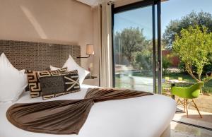 马拉喀什Oasis lodges的卧室设有白色的床和大窗户