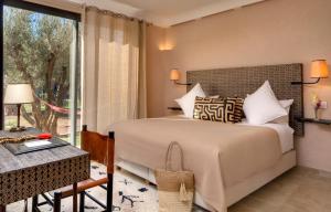 马拉喀什Oasis lodges的一间卧室设有一张床和一个大窗户