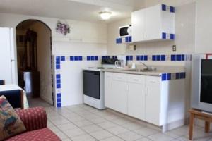 哈瓦苏湖城哈法苏旅馆&套房酒店的厨房配有白色橱柜和蓝色及白色瓷砖